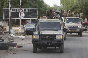 A convoy of Chadian soldiers passes by a signboard painted by Boko Haram in the recently retaken town of Damasak, Nigeria, March 18, 2015. Armies from Nigeria, Cameroon, Chad and Niger have launched an offensive to end Boko Haram's six-year campaign, which has killed thousands in northern Nigeria and spilled over into Cameroon and Niger. REUTERS/Emmanuel Braun (NIGERIA - Tags: CIVIL UNREST MILITARY POLITICS)